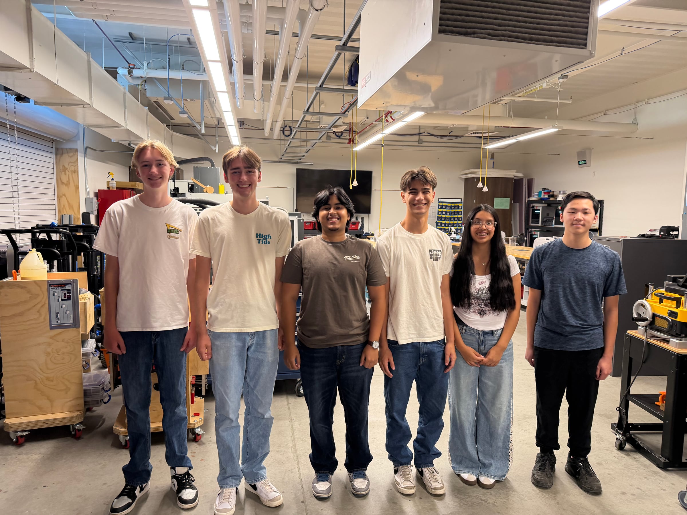 The six members of the 2026 Sanger STEM Camp team standing together in the engineering classroom