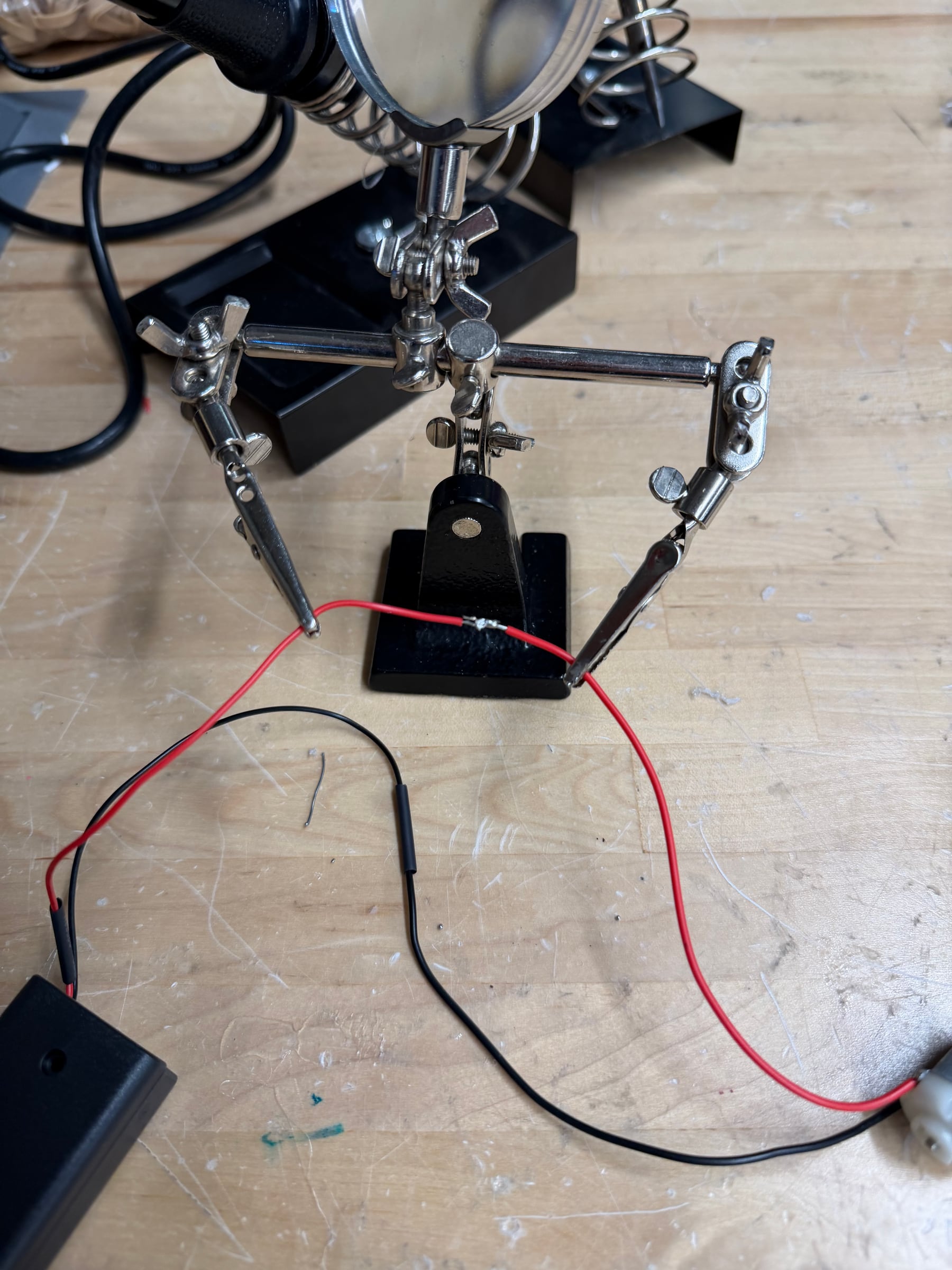 Soldering station prepared with helping hands, soldering iron, heat gun, solder, motors, and battery holders