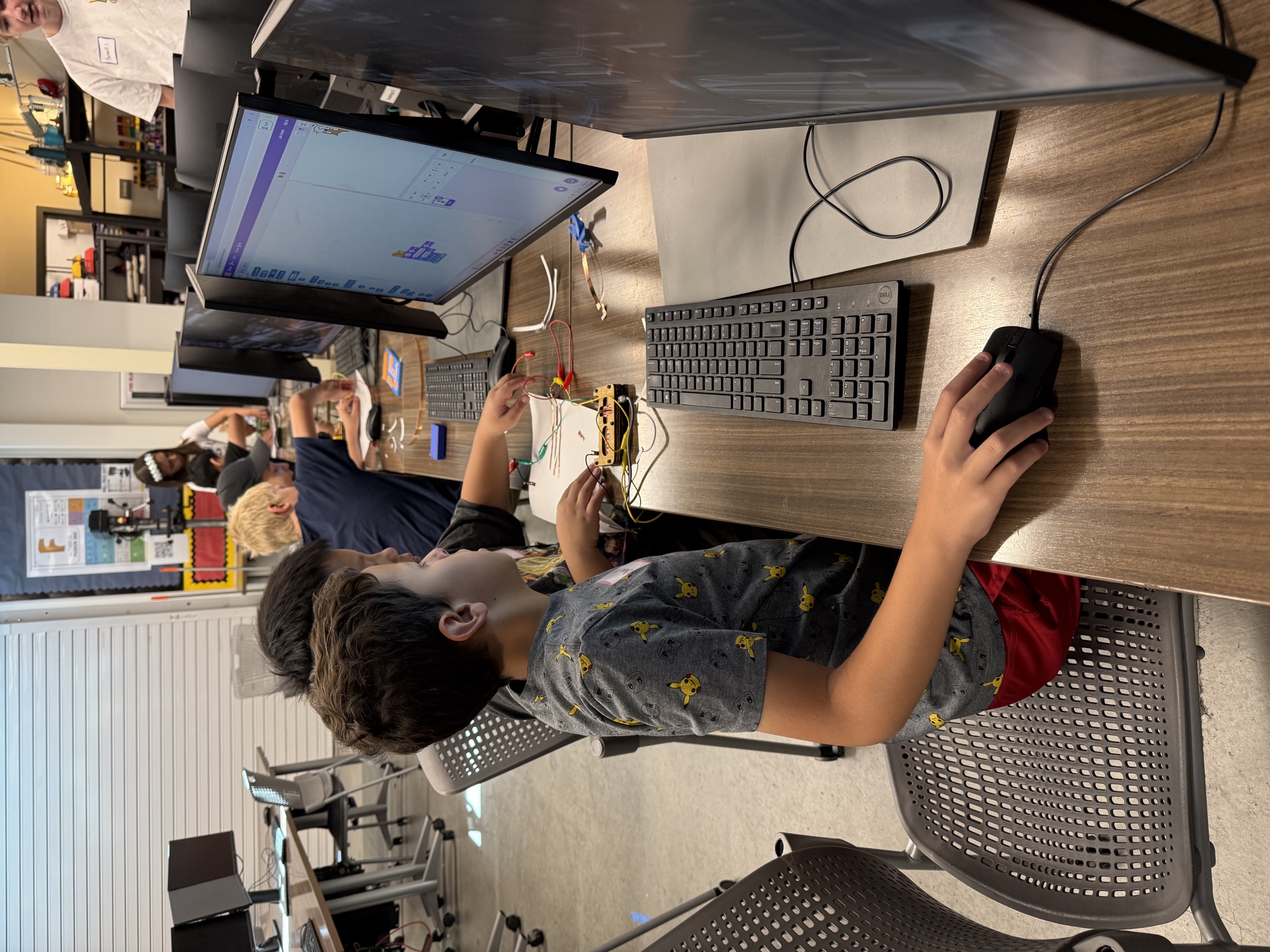 Students programming Scratch while their Makey Makey instrument is connected