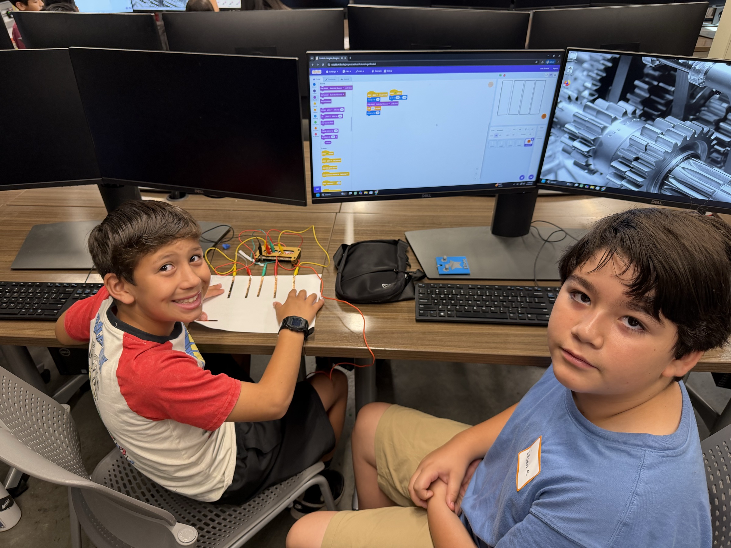 Students testing a copper-tape instrument with Scratch