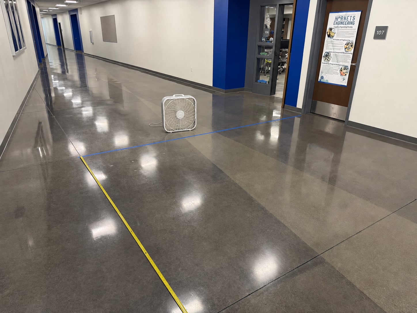 Wind-powered car testing hallway with a box fan, starting line, and tape measure