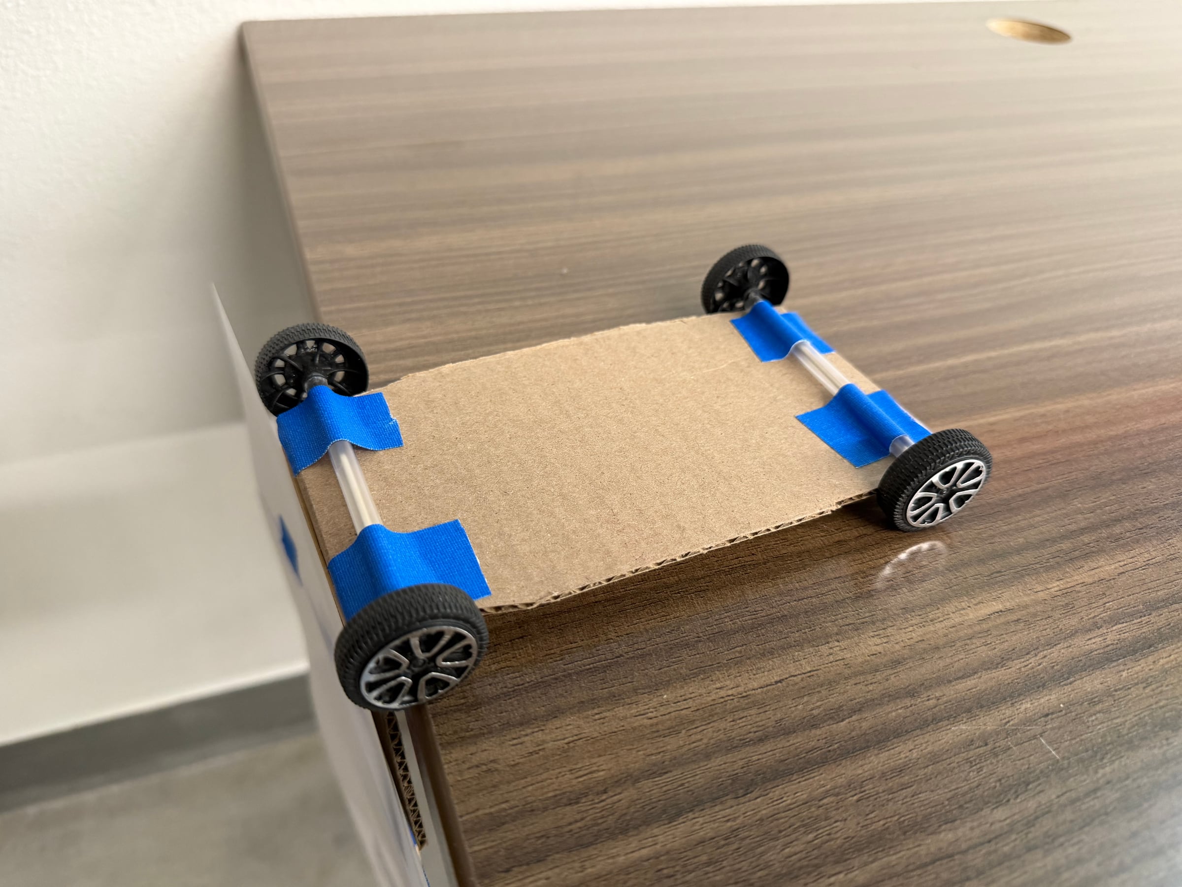 Underside of the instructor-built car showing taped straw axle supports